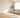 Sunlit living room with a cream sofa, area rug, hardwood floor, and ceiling fan