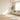 Sunlit living room with a cream sofa, area rug, hardwood floor, and ceiling fan